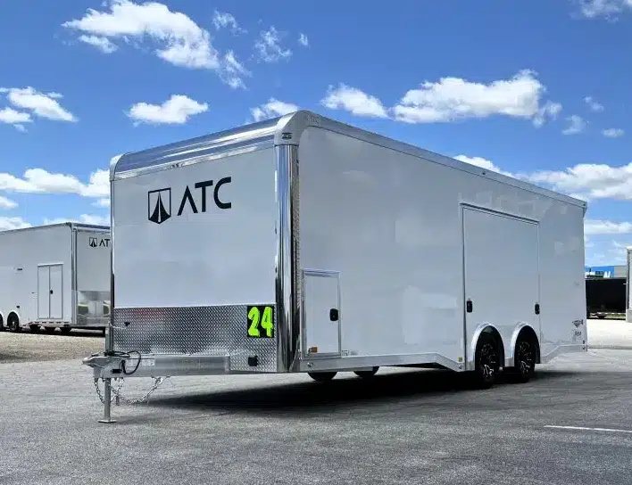 2025 ATC 24 ft Car Hauler – Large Escape Door – Left side exterior three-quarter view showing the large escape door and stone guard