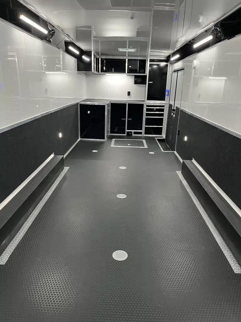 2025 Haulmark Edge 28 ft Car Trailer – Blackout, Turbo – Full interior view showing LED lighting and cabinetry from rear ramp area