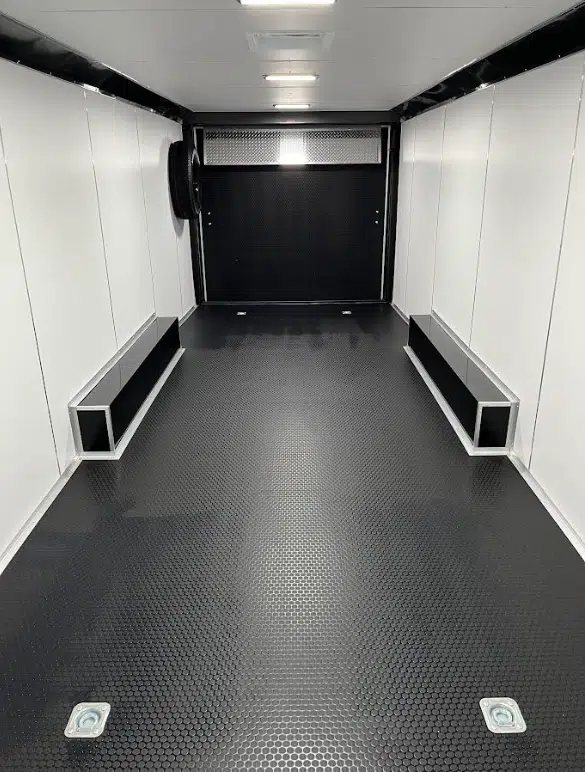 2026 Millennium 28 ft Car Hauler – White – Clean interior view showing black coin flooring and white walls with ceiling lights
