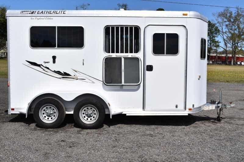 2005 Featherlite 2HST Horse Trailer – Walk-Through Dressing Room – White horse trailer side profile with black graphic decal and dual axles