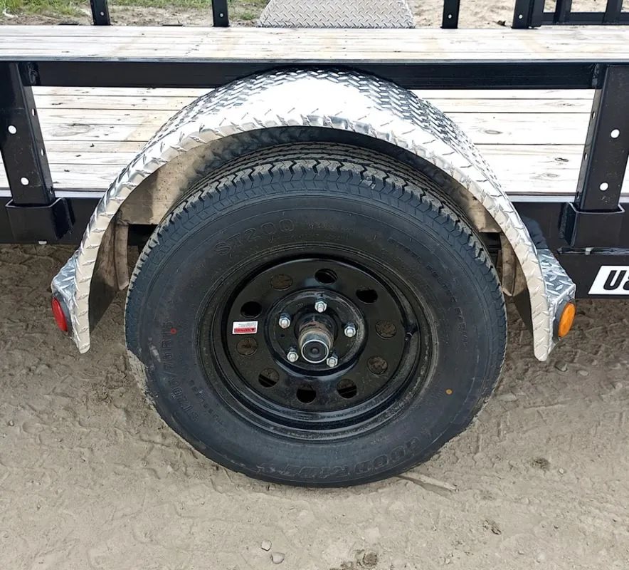 2024 PJ Trailers 14 ft Utility – Side Loading Ramps – Close up of trailer wheel and tire under a diamond plate fender