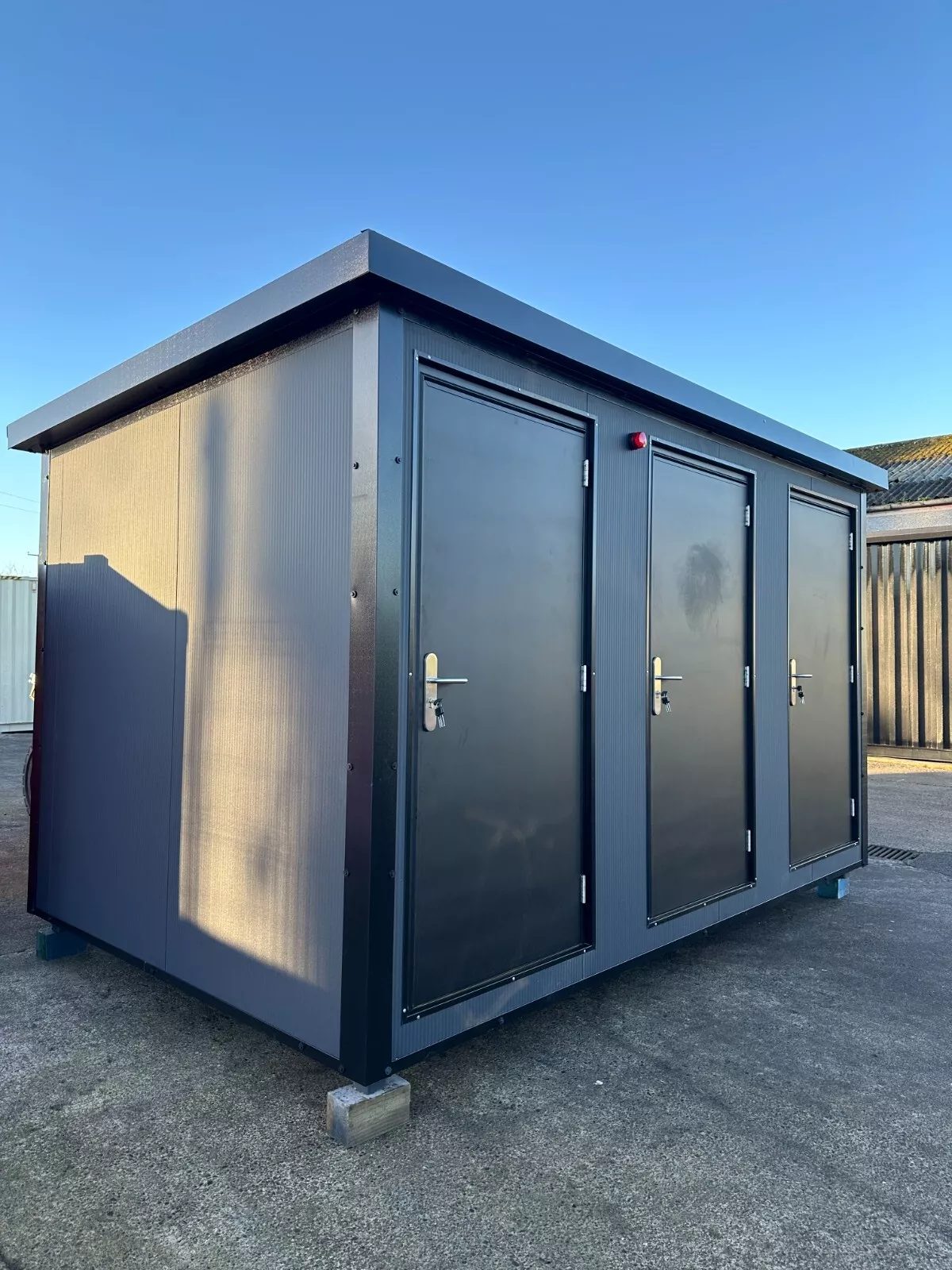 Custom Shipping Container Restroom – Three Private Compartments – three-quarter exterior view of restroom unit with three closed doors