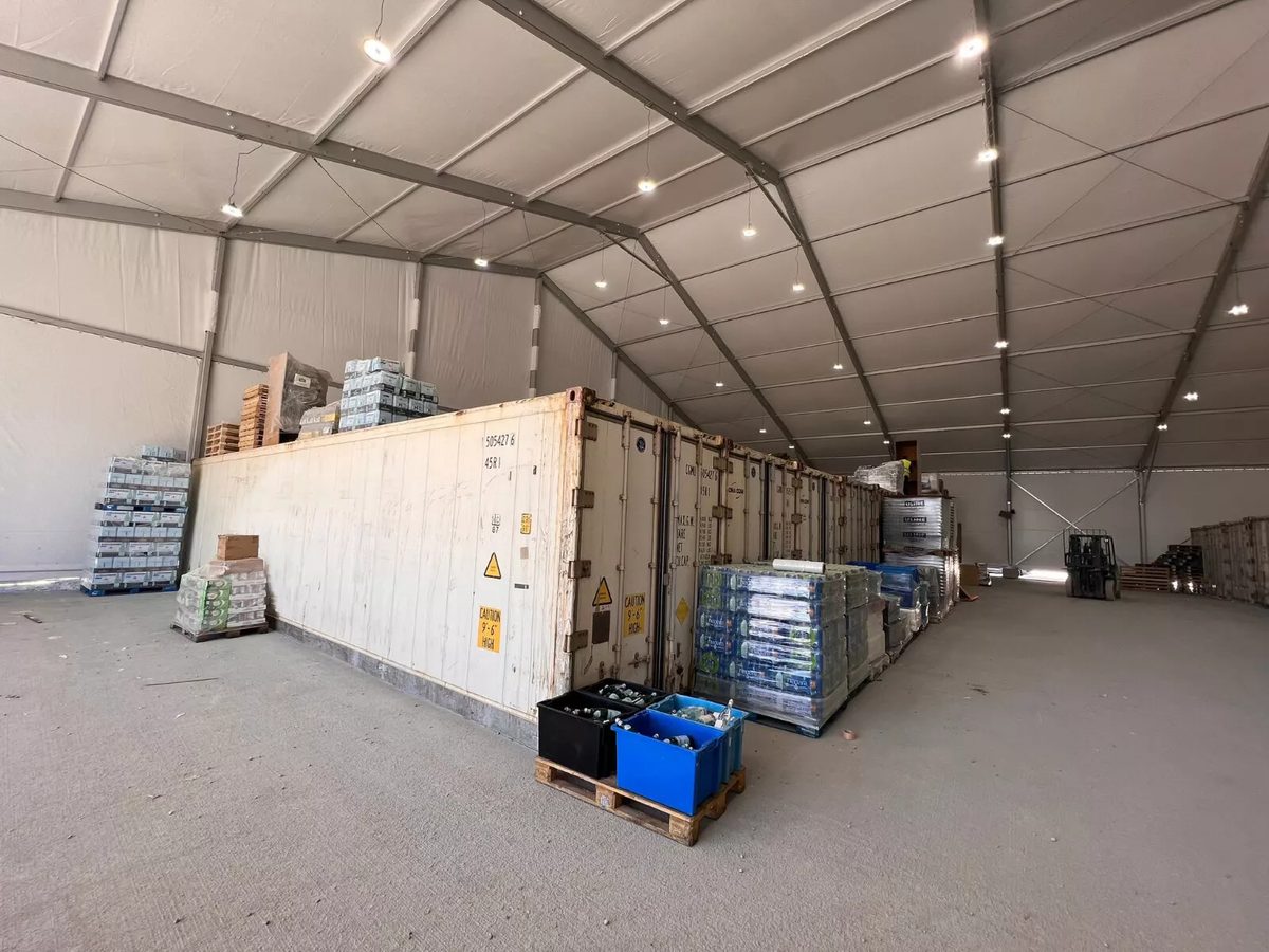 40ft High Cube Reefer Container – Carrier PrimeLINE – white refrigerated containers surrounded by stacked supplies inside warehouse