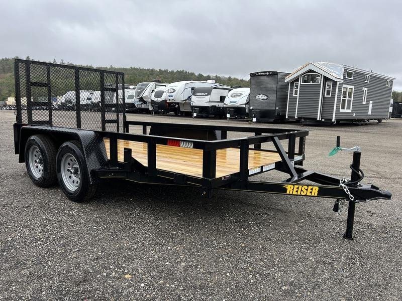 2024 Reiser Trailers 12 ft Landscape Trailer – Ramp Gate – Front three-quarter view of a black utility trailer with wooden deck on a gravel lot