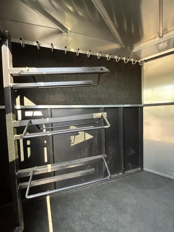 2022 Logan Coach Crossfire 3 Horse Trailer – Swing-Out Saddle Rack – Swing-out saddle rack system and bridle hooks on a carpeted wall