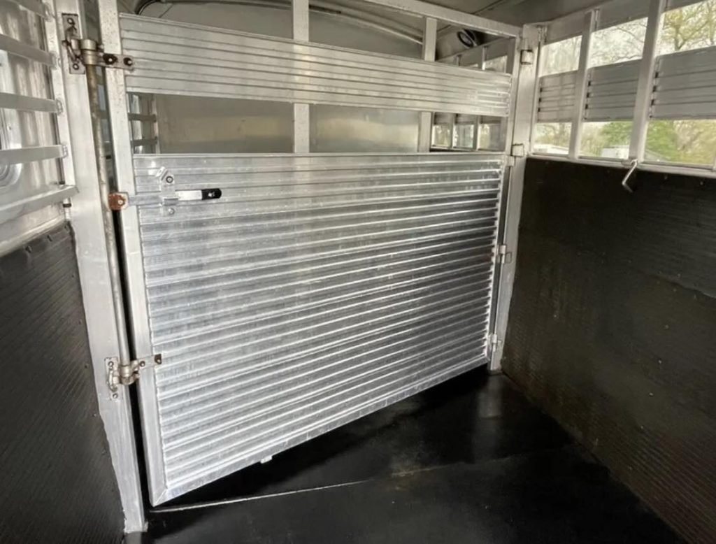 1999 4 Star 2 Horse Trailer – Reverse Slant / Stock Combo – The interior horse stall area with metal dividers and rubber matted walls