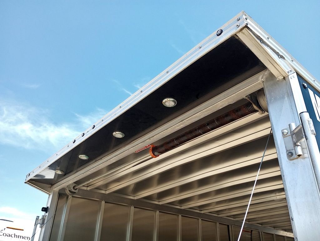 Mission Trailers 22 ft Snowmobile Trailer – 4-Place – Underside view of the rear header showing lights and the ramp spring mechanism