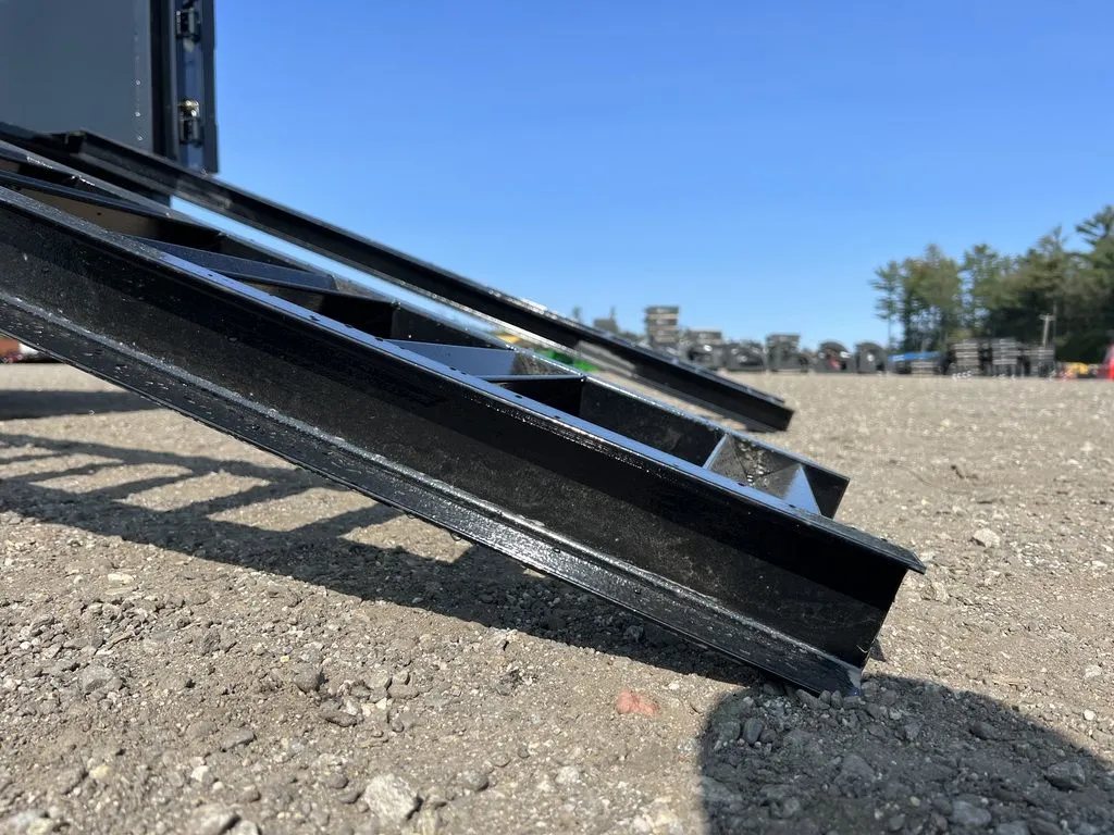 2024 Griffin Trailers 16 ft Dump Trailer – Telescopic – A low-angle close-up view of a metal ladder-style loading ramp