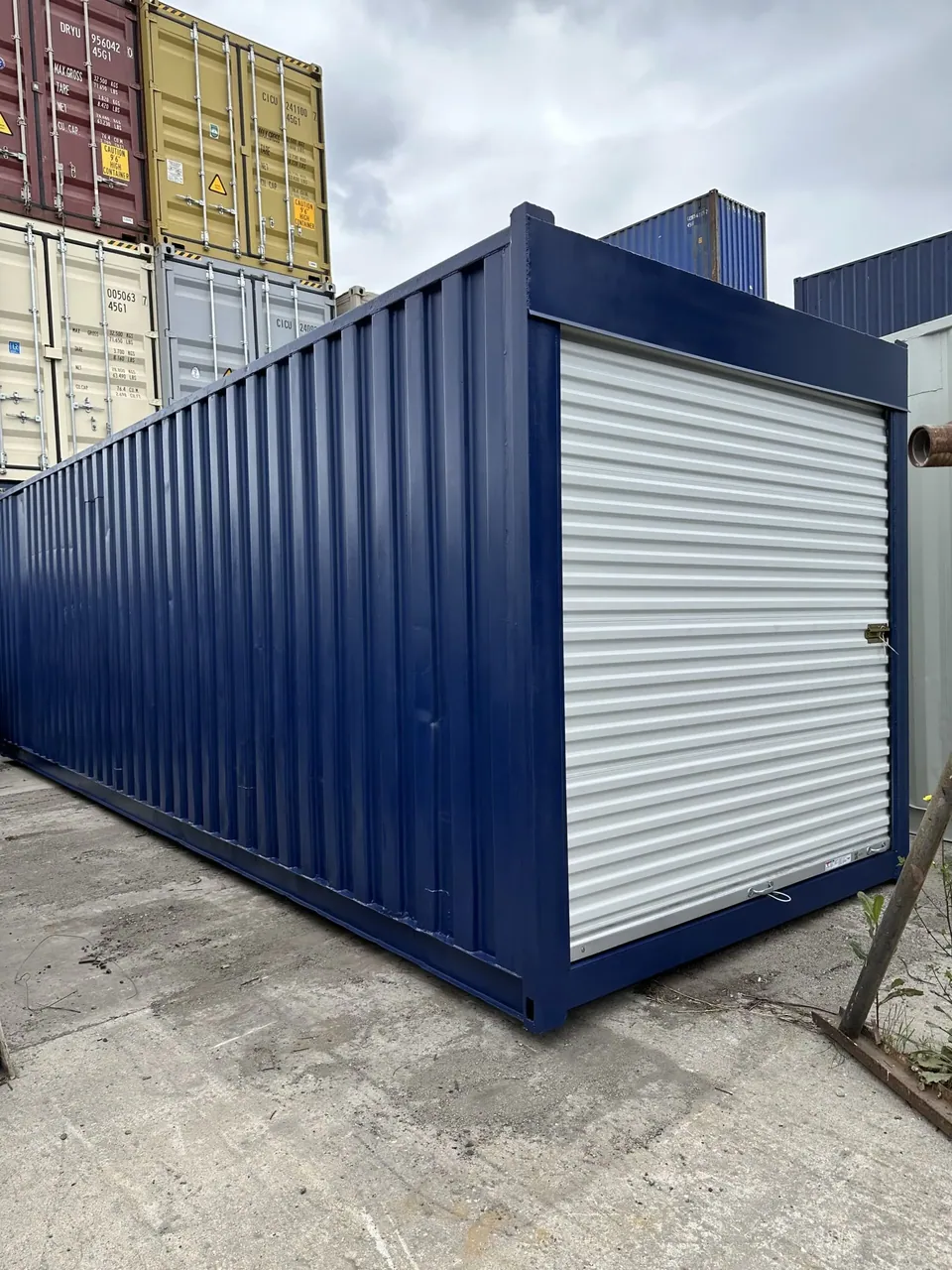 30ft Modified Storage Container – Roll-Up Access – Three-quarter exterior of blue container with closed white roll-up door