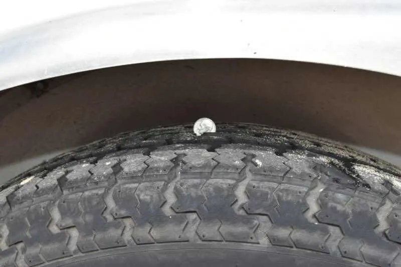 2016 Shadow 2 Horse Trailer – Aluminum, Dressing Room – Detail shot of tire tread depth being measured with a coin