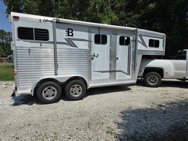 2000 C&C 2 Horse Gooseneck Trailer – Aluminum, Dressing Room – Right three-quarter exterior view of a silver gooseneck horse trailer attached to a truck