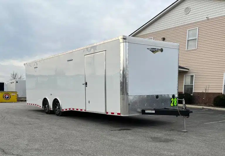 2026 Millennium Extreme 28 ft Enclosed Car Hauler – White – White enclosed car hauler trailer with side door and black wheels parked on asphalt