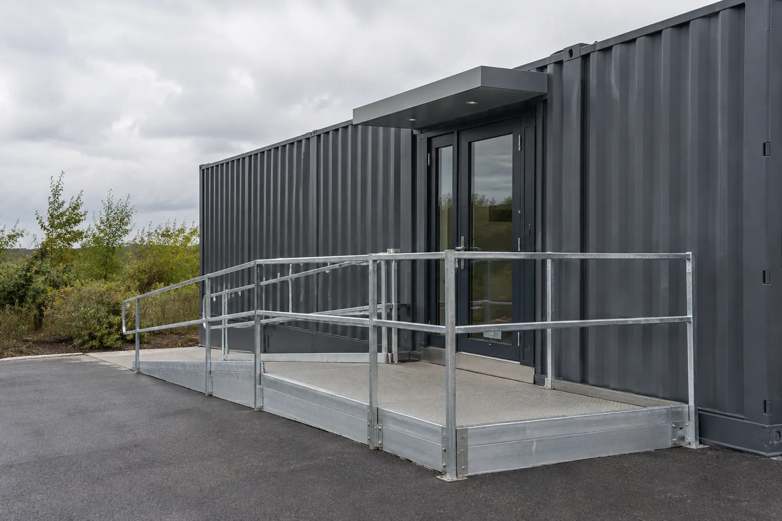 Accessible container pop up shop entrance with ramp, handrails, and a level landing